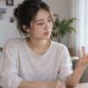 自宅で自分の手を見つめる女性