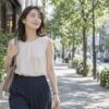 夏の街でノースリーブの服を着て歩く女性