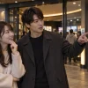 映画館の上映案内を見ながら相談する男女
