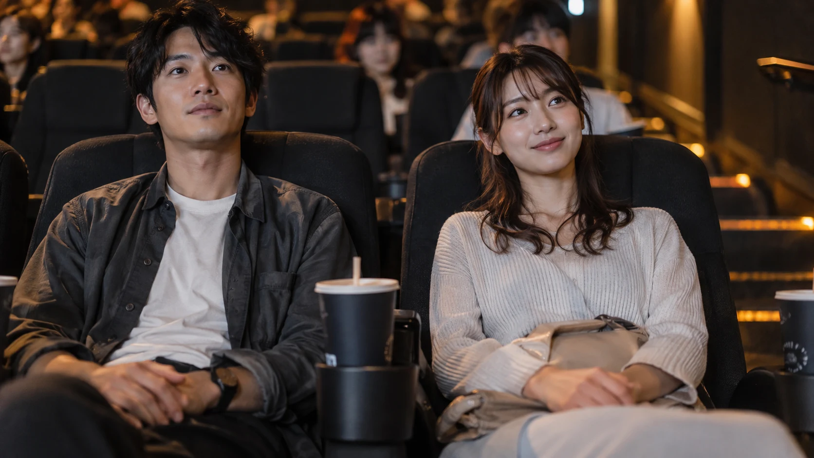 映画館でそれぞれの席に座って上映を待つ男女