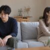 言い争いの後にソファで距離を置いて考える男女