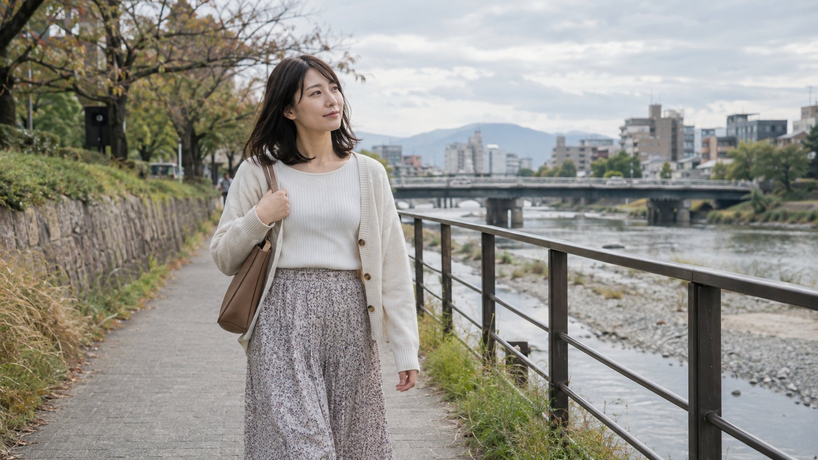 川沿いの道を一人で散歩する女性