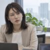 職場で同僚の話を真剣な表情で聞く女性