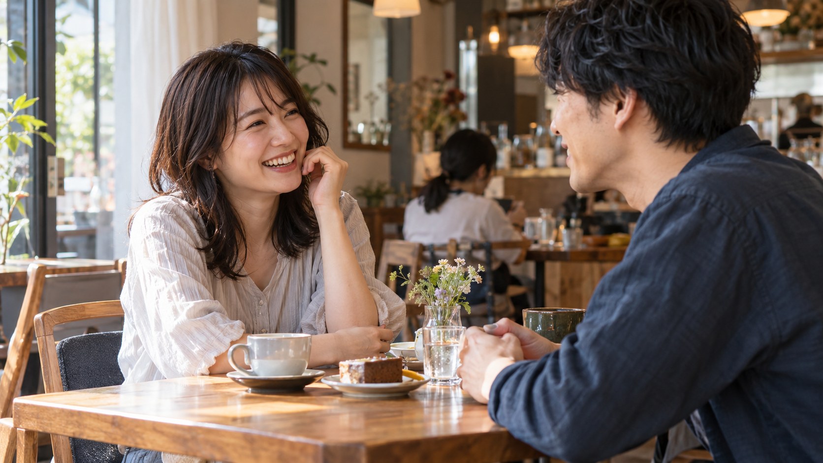 カフェで気取らず笑いながら男性と話す女性