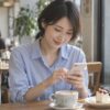 カフェでスマートフォンにメッセージを入力する女性