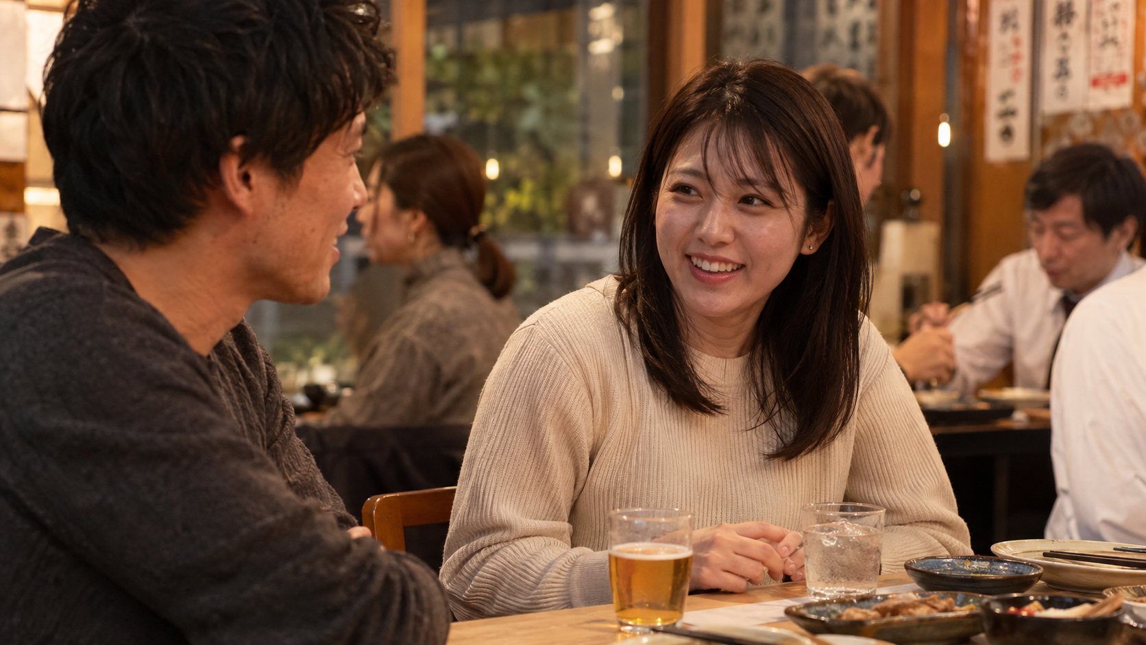 飲食店で男性の友人と会話する成人女性