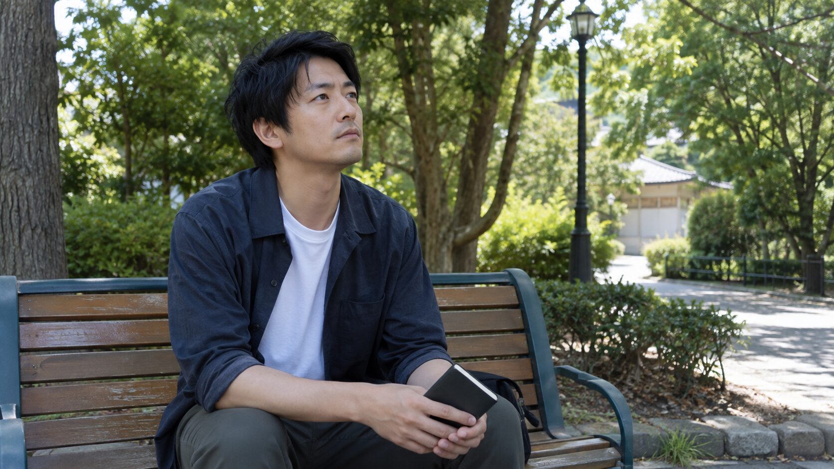 公園のベンチで会話を振り返る男性