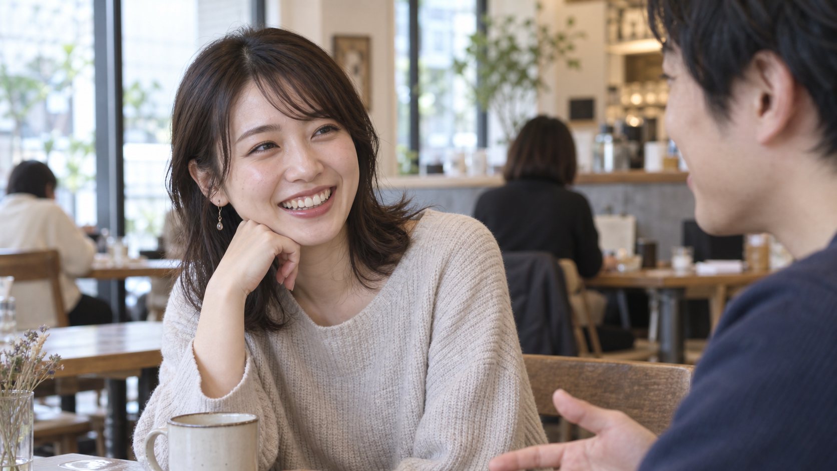 カフェで男性の話を聞いて自然に笑う女性