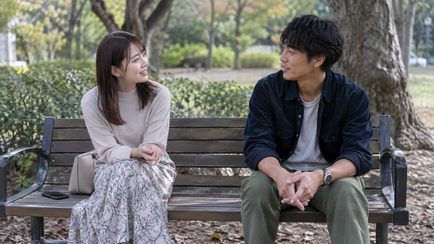 公園のベンチで会話する男女