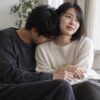 ソファで女性の肩から首元にそっと顔を寄せる男性