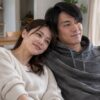 ソファで恋人の肩にそっと寄り添う女性