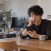 自宅でメッセージを読み考える男性