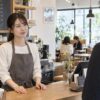 カフェのカウンター越しに、穏やかに接客する女性店員