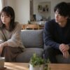 少し距離を置いて座り、静かに考える女性と見守る男性