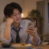 仕事を終えて自宅でメッセージを読む男性