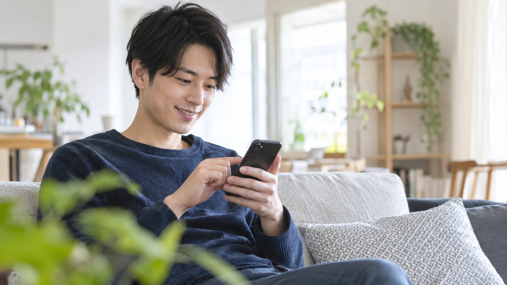 自宅でスマートフォンから返信を考える男性