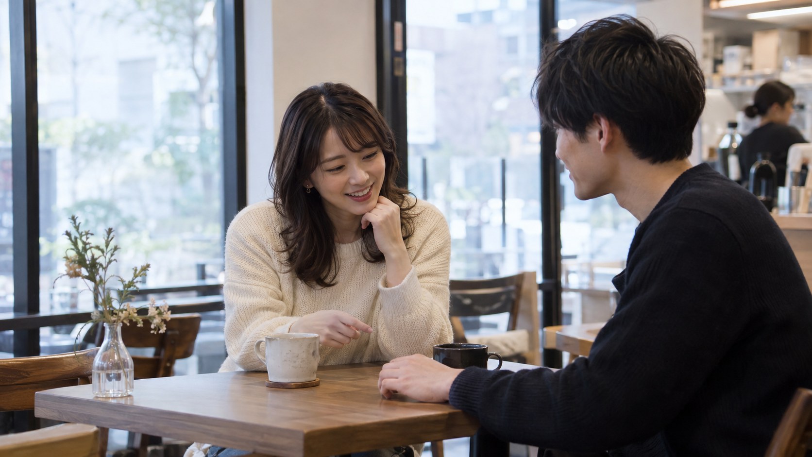 カフェで男性の手に目を向ける女性