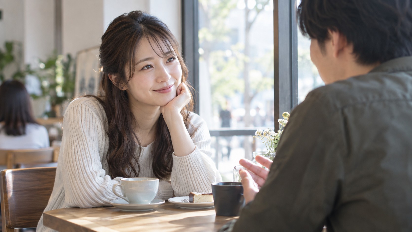 カフェで恋人の話を笑顔で聞く女性