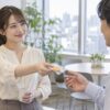 職場の休憩スペースで男性の同僚に個包装のお菓子を渡す女性
