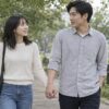 公園を歩きながら自然に手を繋いで会話する男女